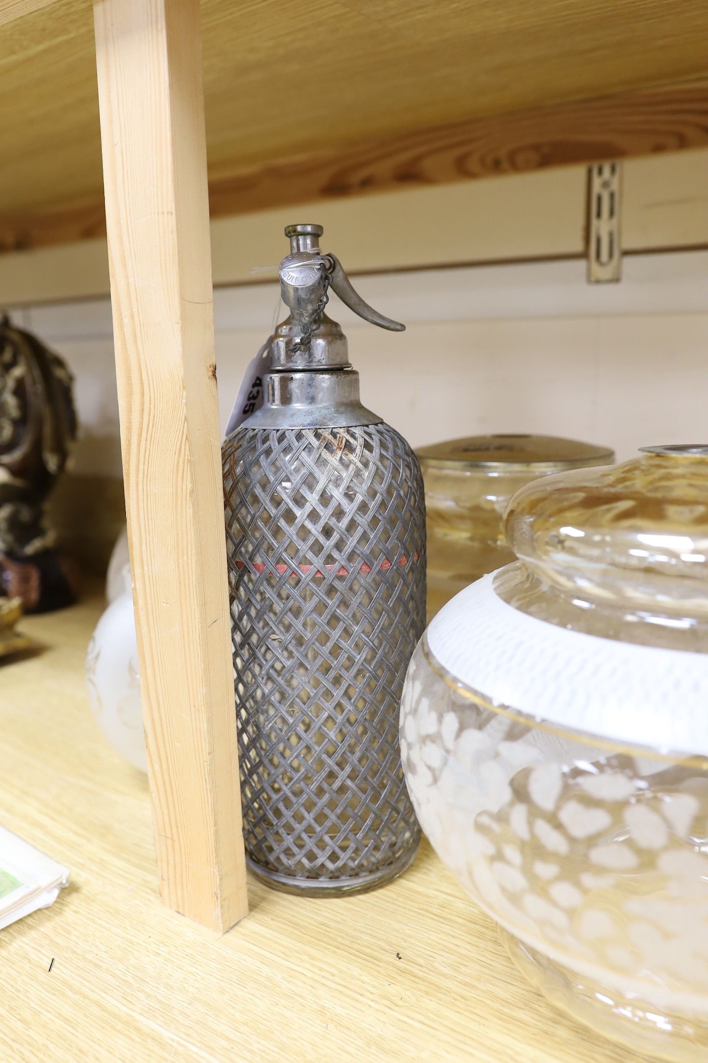 A group of glass lamp shades and an electroplate mounted syphon